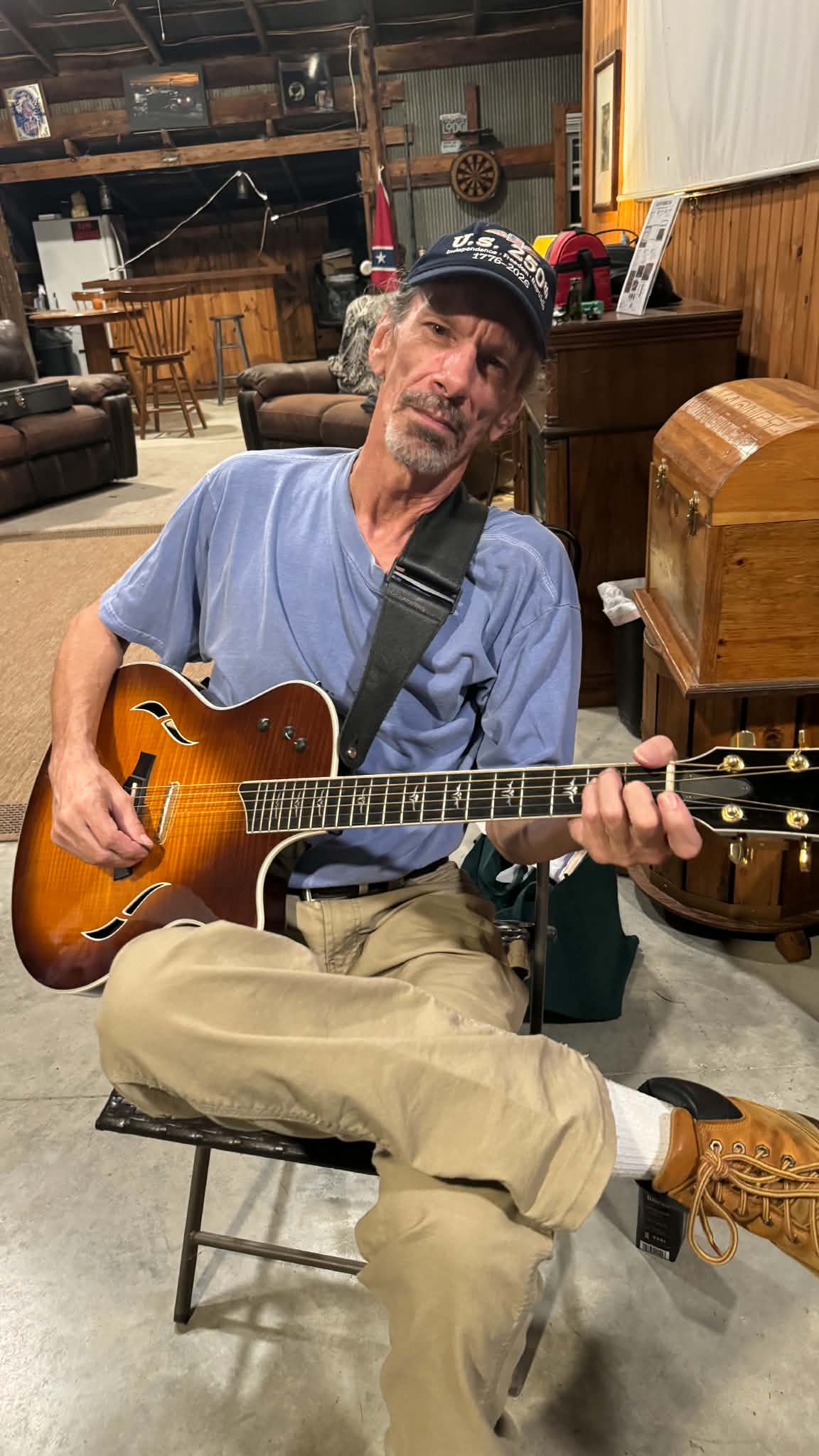 Roy Earl Robison seated with his guitar at Beck's Creek Ranch